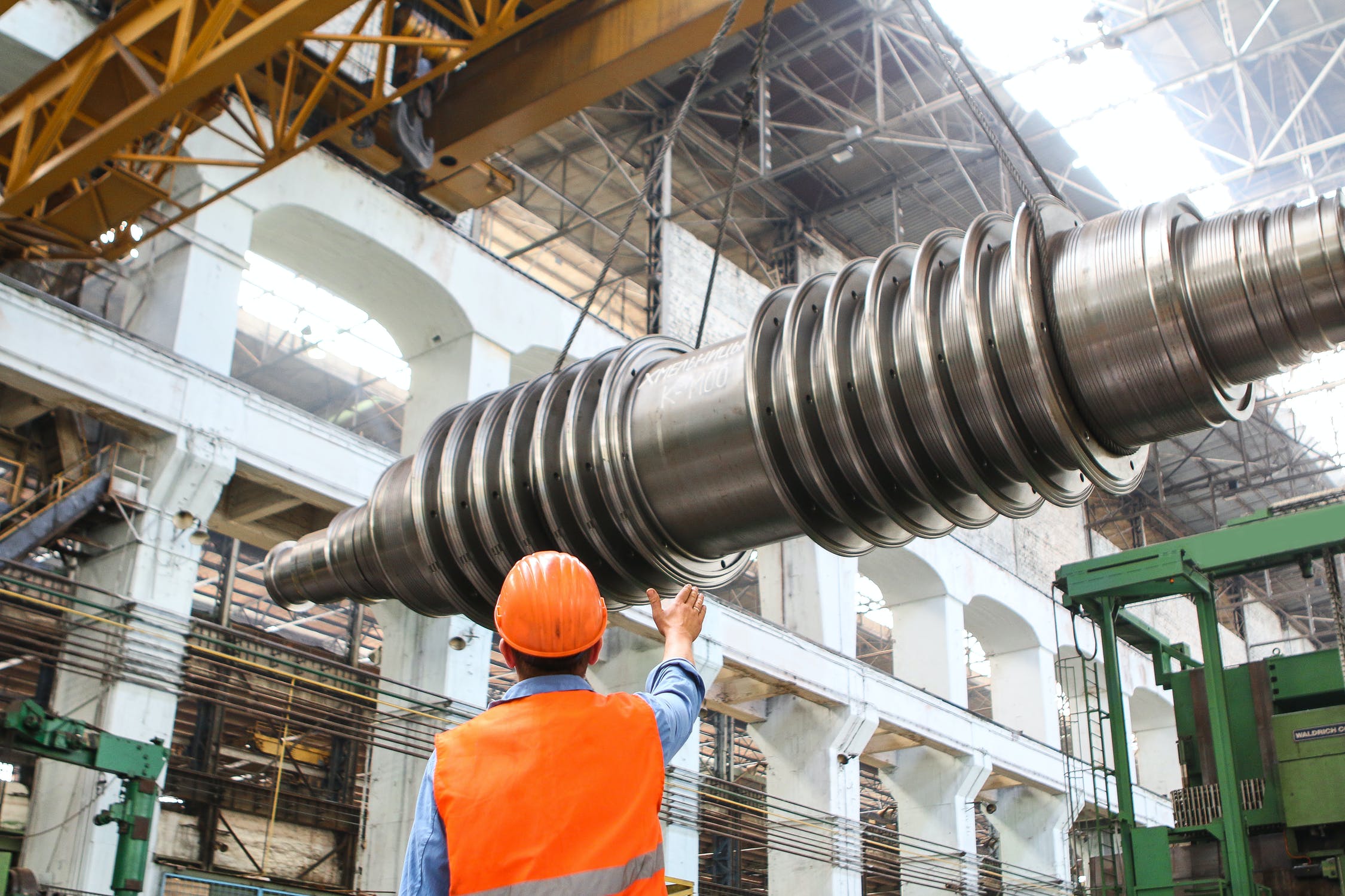 Factory Worker moving heavy spiral part